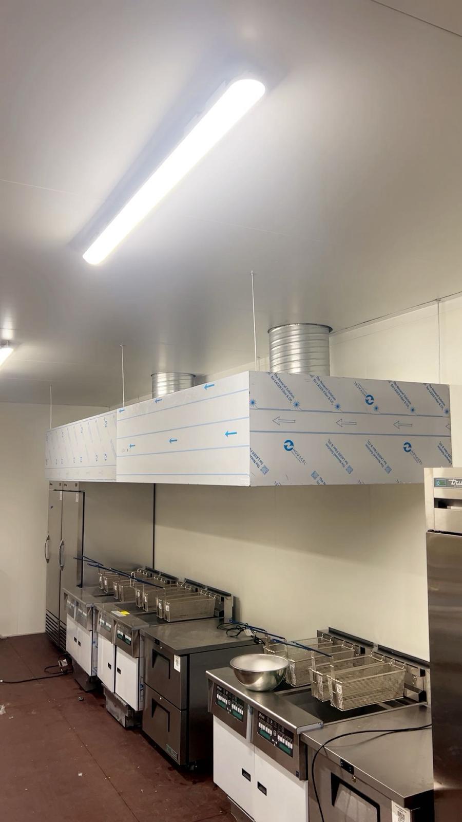 Hotte neuve avec conduits d'extraction installée en cuisine professionnelle — BATI CLIM 17